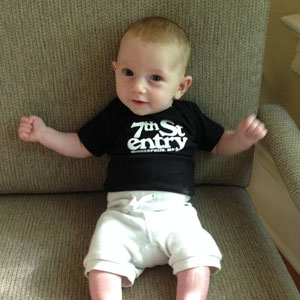 Black onesie with the 7th St Entry logo screenprinted in white on the chest