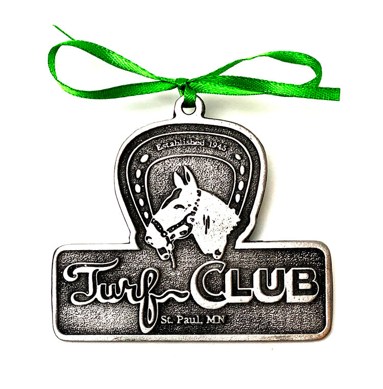 Decorative metal ornament with horse design and 'Turf Club' text, tied with a green ribbon.