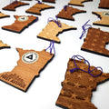 Wooden ornaments shaped like Minnesota with engraved First Avenue logo on the back, and stars/brick design on the front