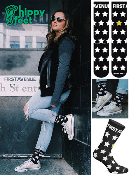 First Avenue x Hippy Feet Socks - black socks with white stars and "First Avenue" in white at the top of each sock. One gold star.